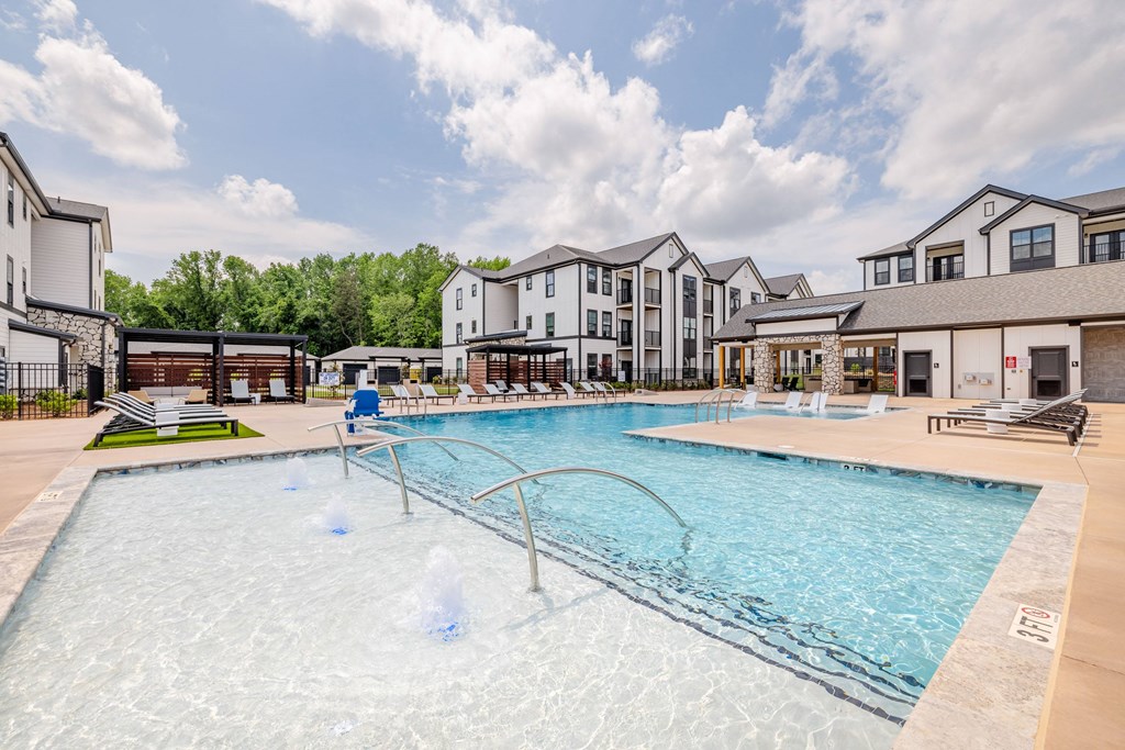 A large swimming pool with a fountain in the middle of it.