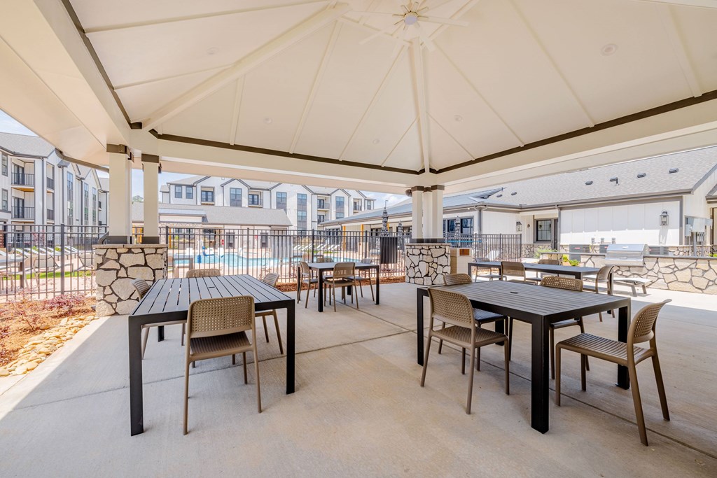 A patio with a table and chairs under a canopy.