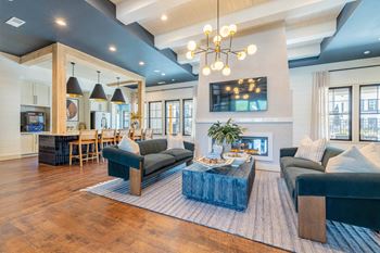 A modern living room with a dark blue couch and a wooden coffee table.