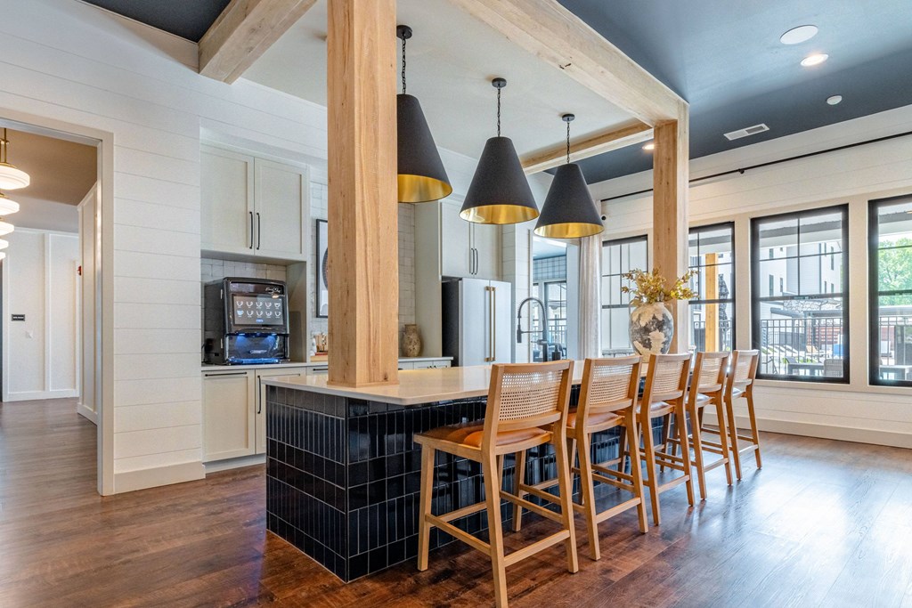 A kitchen with a bar and chairs.