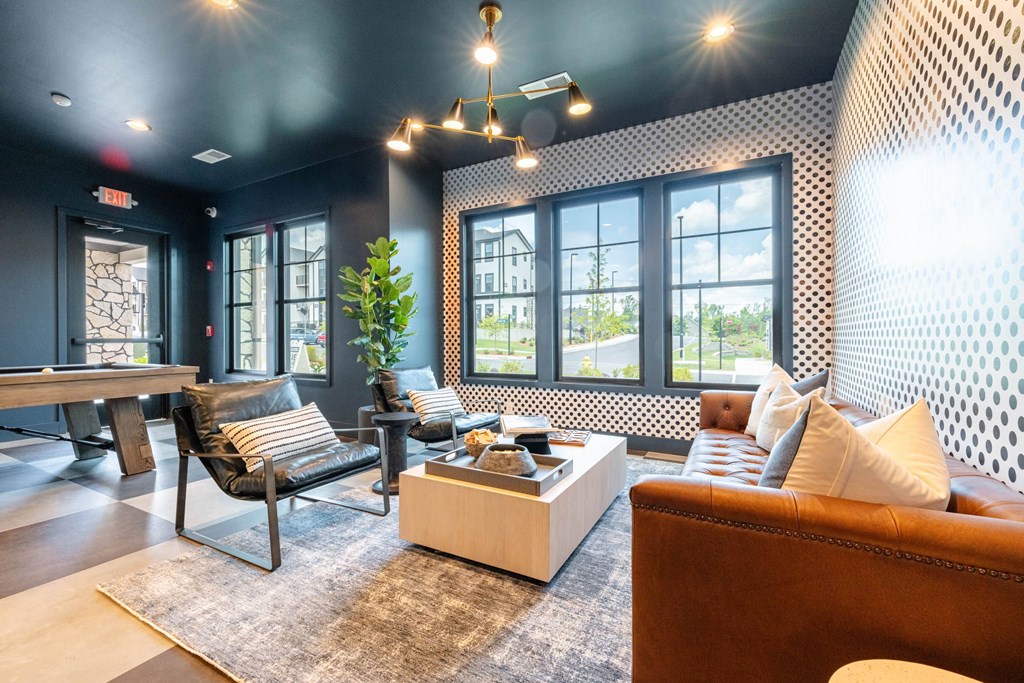 A living room with a brown couch, a coffee table, and a large window.