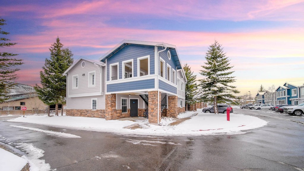 a blue house with a red fire hydrant in the snow