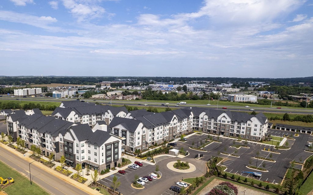 an aerial view of an apartment complex with a parking lot