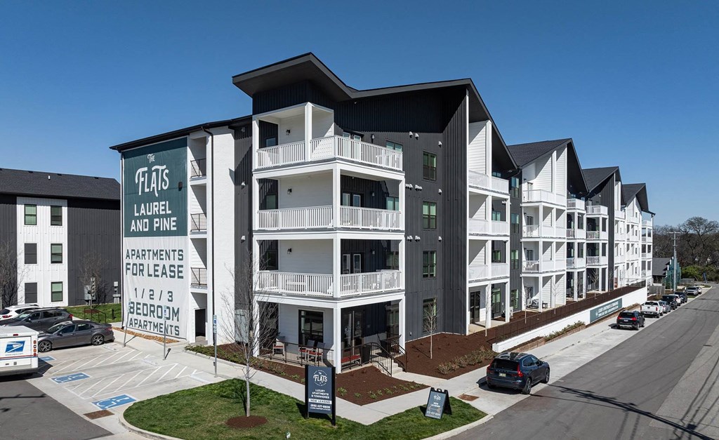 an apartment building with cars parked in front of it