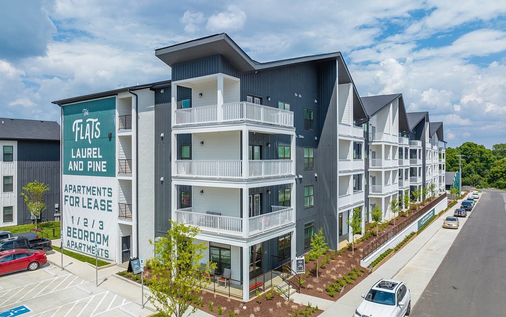 an apartment building with cars parked in front of it