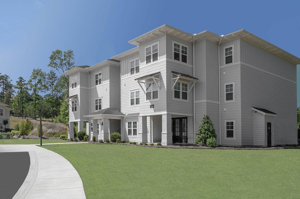 a large apartment building with a lawn in front of it