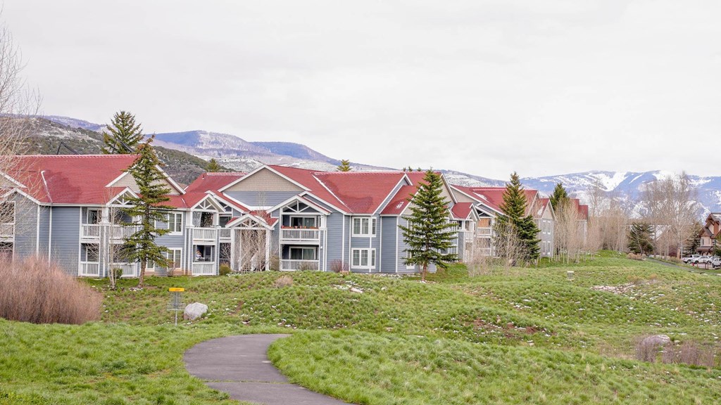 a group of houses with mountains in the background