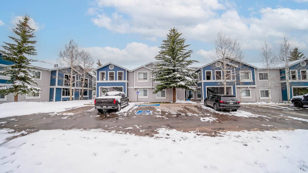 a row of houses with trucks parked in the snow