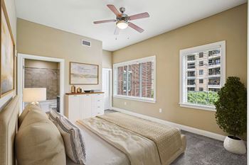 A bedroom with a bed, nightstand, and a ceiling fan.
