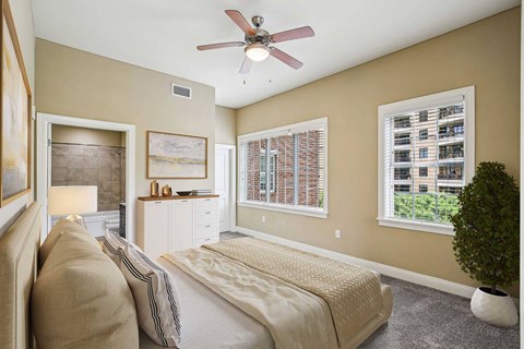 A bedroom with a bed, nightstand, and a ceiling fan.