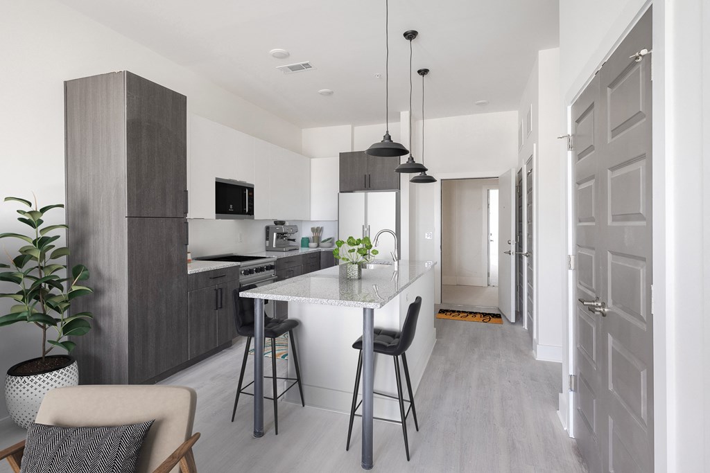 a kitchen with an island and bar with stools
