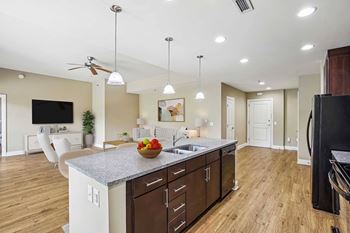 A kitchen with a counter top and a bowl of fruit on it.
