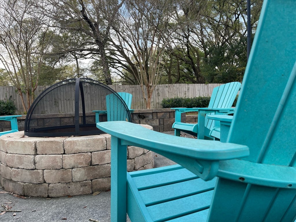 a group of turquoise chairs sitting around a fire pit