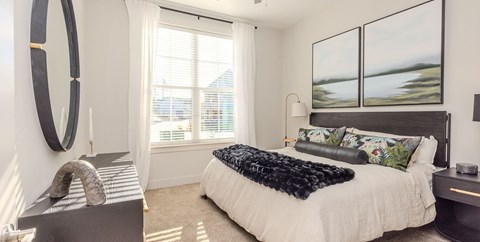 A bedroom with a large bed and a large window.