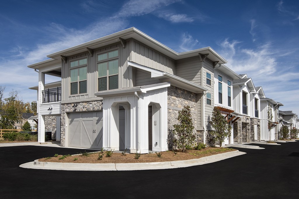a street view of a building with white columns and gray and white facade with columns