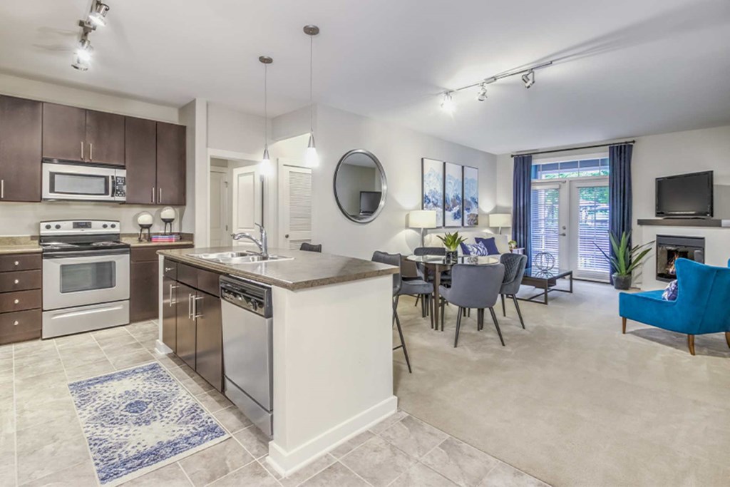 A kitchen with a white island and a blue rug on the floor.