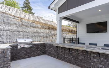a covered patio with a grill and a television