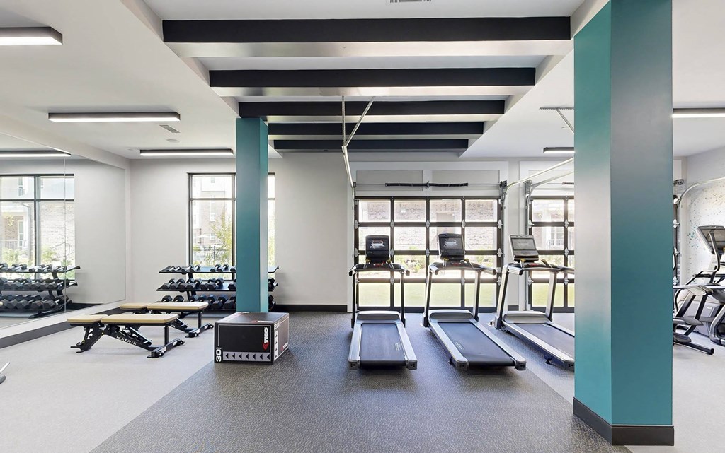 the gym has treadmills and other exercise equipment in a room with windows