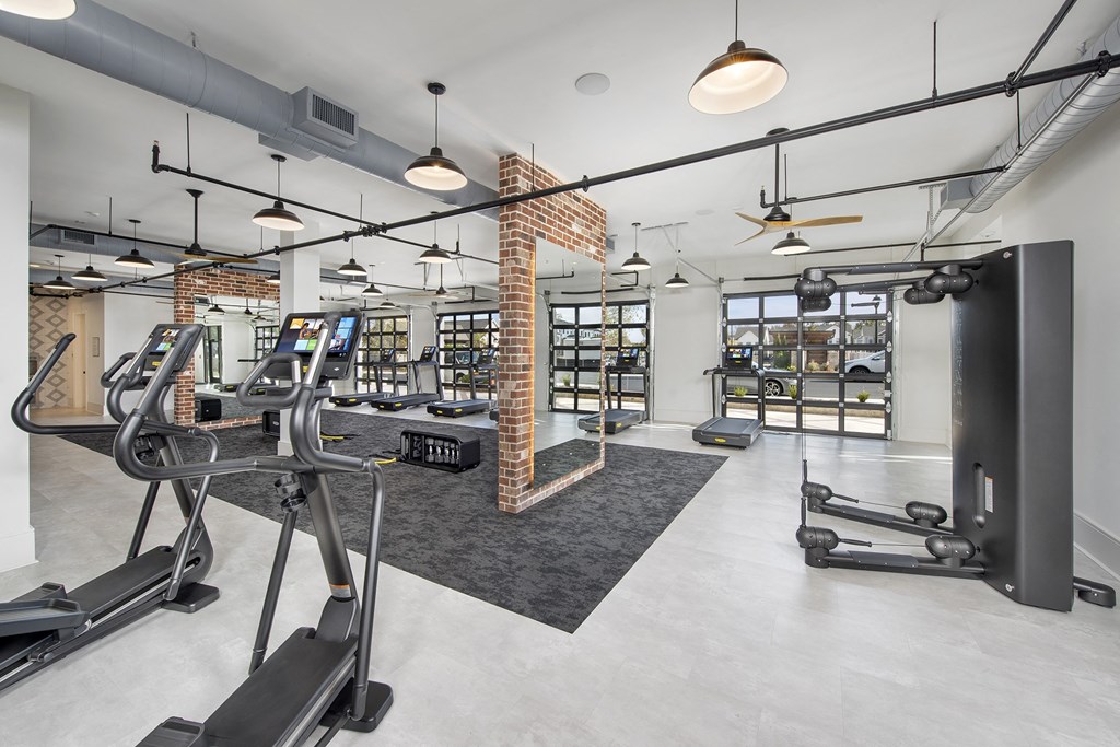 a gym with treadmills and other exercise equipment in a building with glass doors