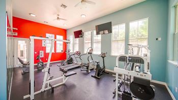 a gym with various exercise equipment and windows