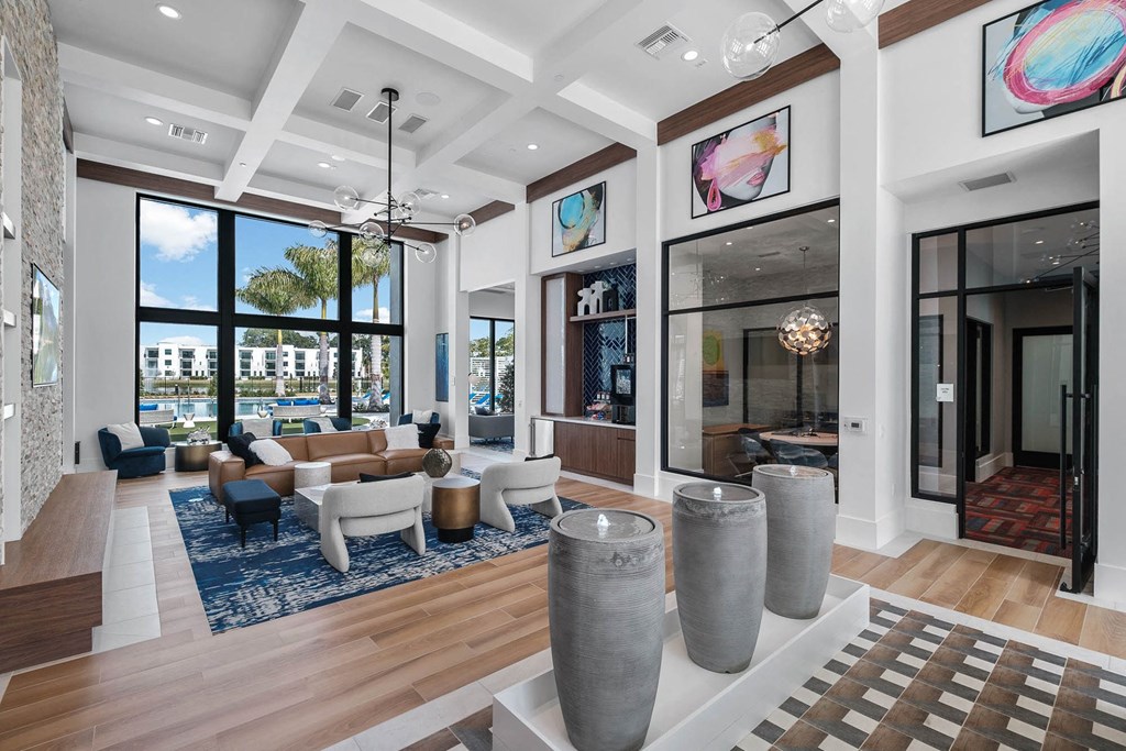 a living room with couches and chairs and large windows at Altis Blue Lake, Lake Worth, 33467