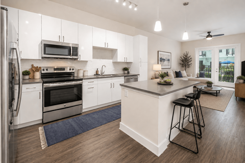 A modern kitchen with white cabinets and a large island.