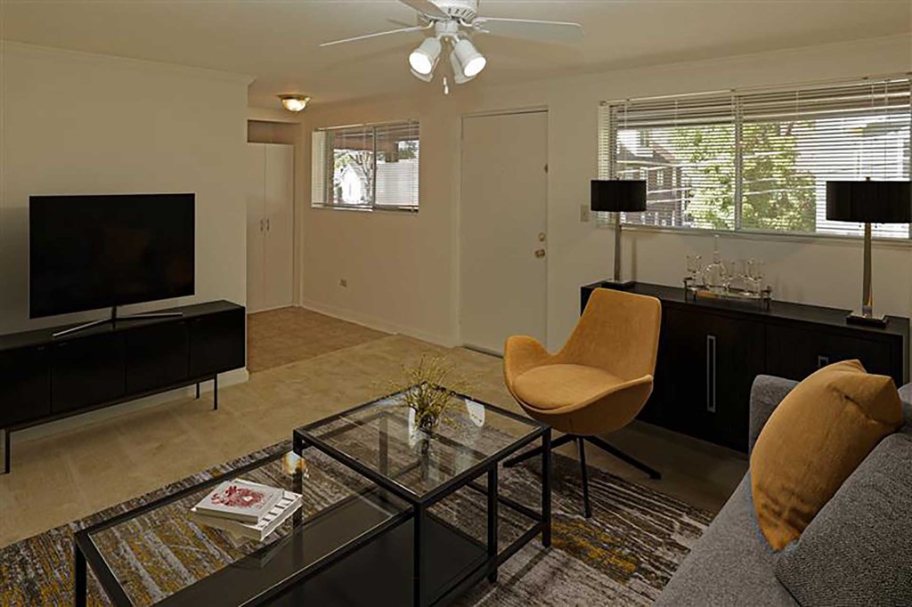 A living room with a television, a chair, and a coffee table.