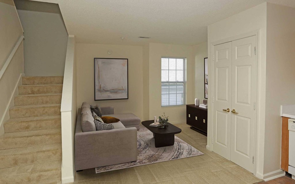 A living room with a couch, a coffee table, and a painting on the wall.