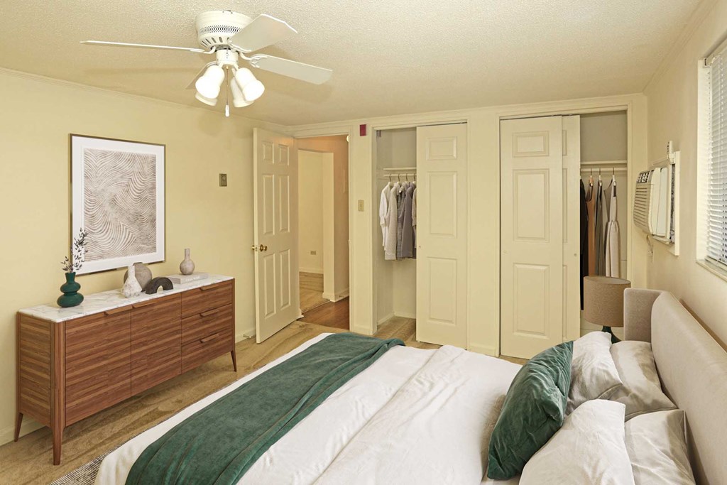 A bedroom with a bed, dresser, and closet.