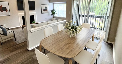 A dining room with a wooden table and white chairs.