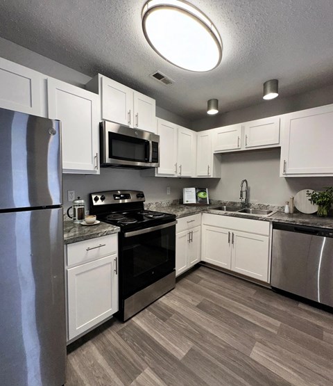 A kitchen with white cabinets and a black stove top.