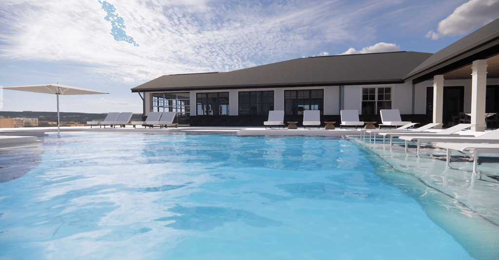 a large pool with white chairs and a building in the background