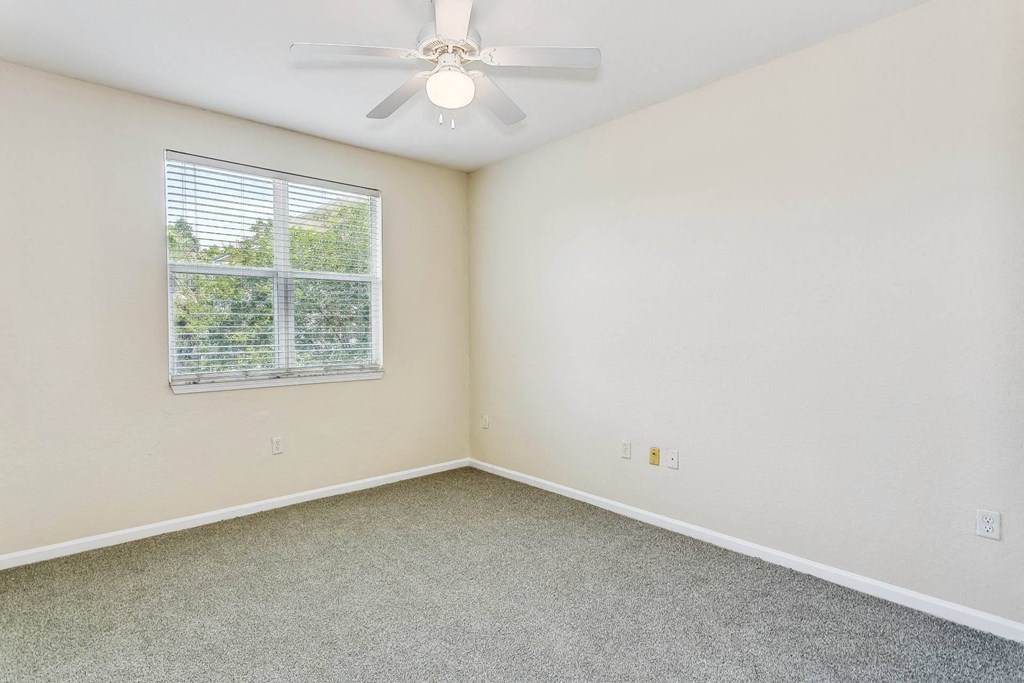 a bedroom with a ceiling fan and a window