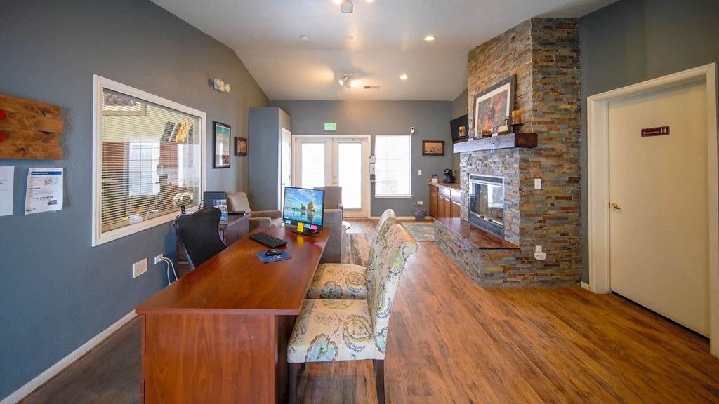 a home office with a wooden desk and a brick fireplace