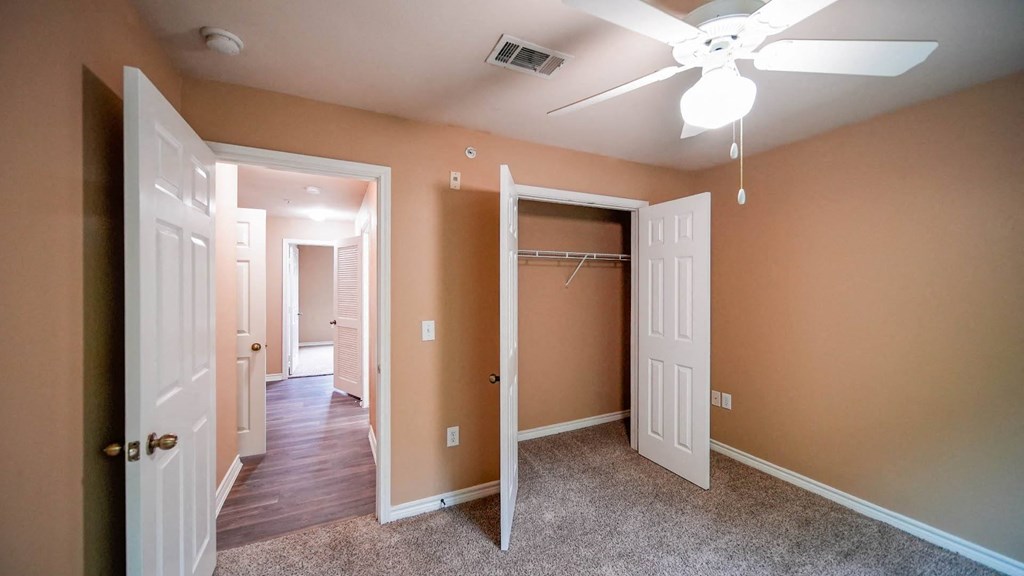 a bedroom with a closet and a ceiling fan