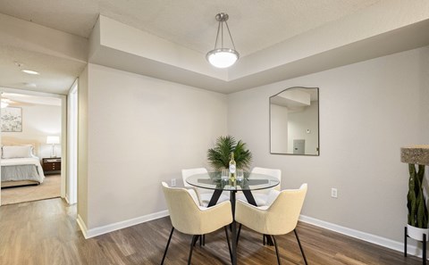 A dining room with a table set for two and a mirror above it.