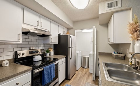 A kitchen with white cabinets and a black stove top oven.