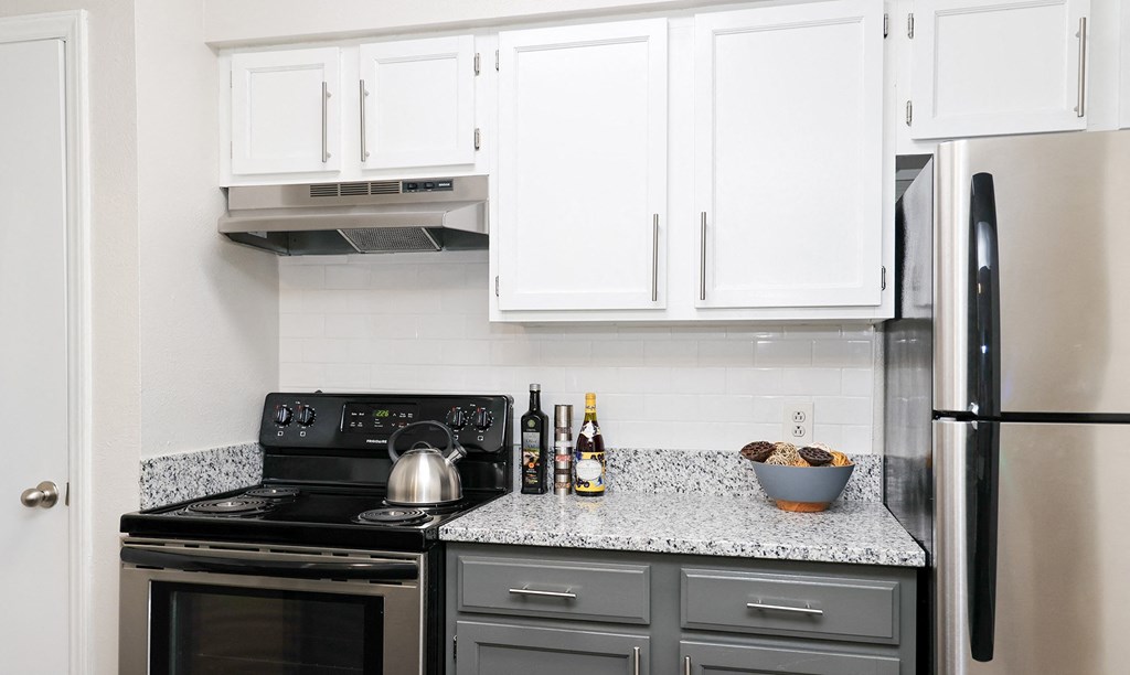 a kitchen with white cabinets and black appliances and a granite counter top