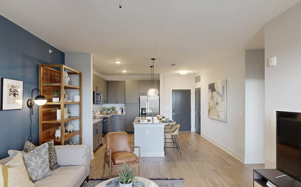 a living room and kitchen with a couch and a table