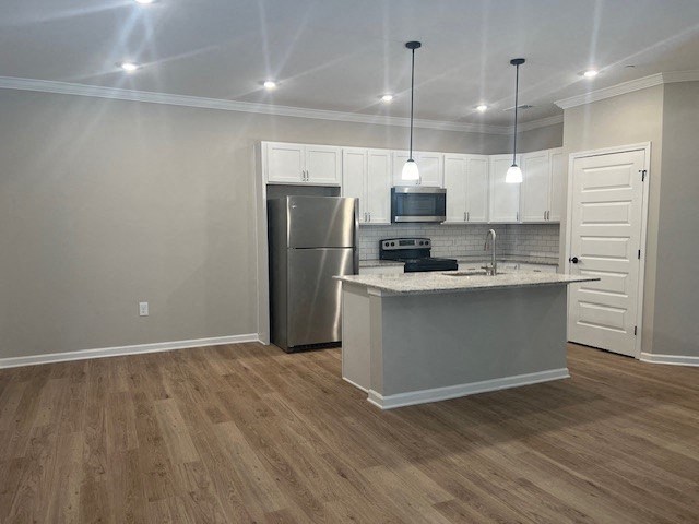 a kitchen with an island and a stainless steel refrigerator