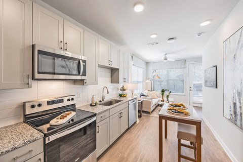 a kitchen with white cabinets and stainless steel appliances and a dining table
