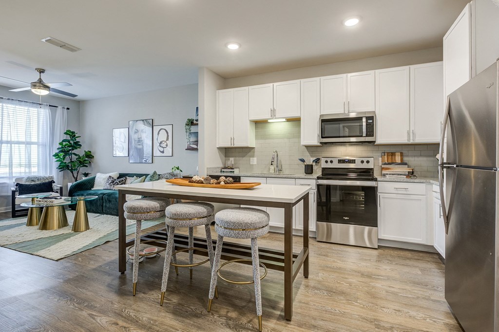 a kitchen with stainless steel appliances and a center island with three stools