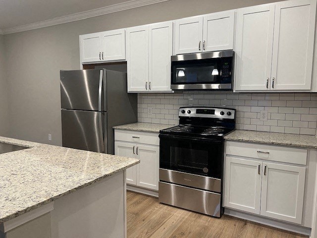 a kitchen with stainless steel appliances and white cabinets