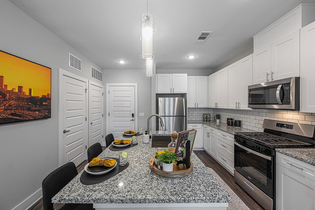a kitchen with white cabinets and a granite counter top