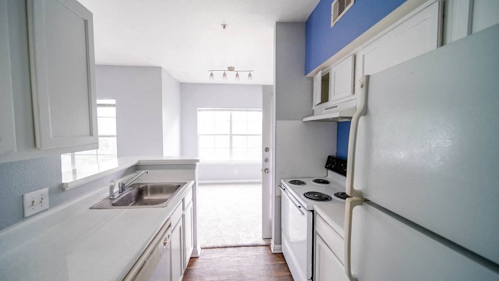 a kitchen with white cabinets and a sink and a refrigerator