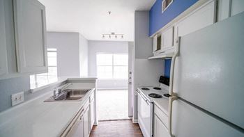 a kitchen with white cabinets and a sink and a refrigerator