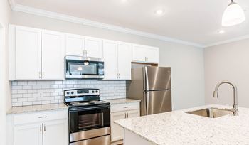 a kitchen with stainless steel appliances and white cabinets