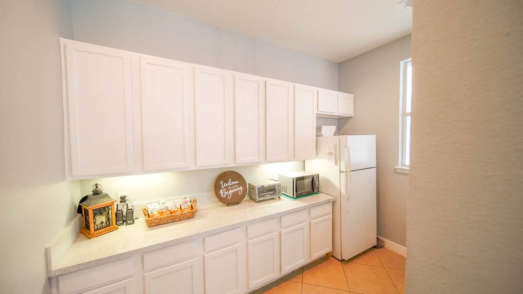 a kitchen with white cabinets and a white refrigerator