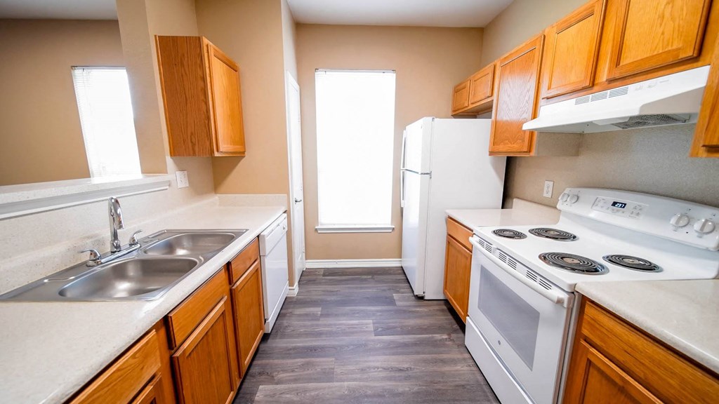 a kitchen with a stove refrigerator and sink