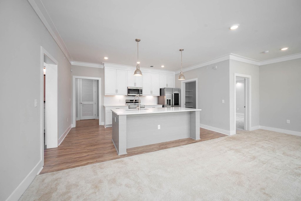 a white kitchen with a large island in the middle